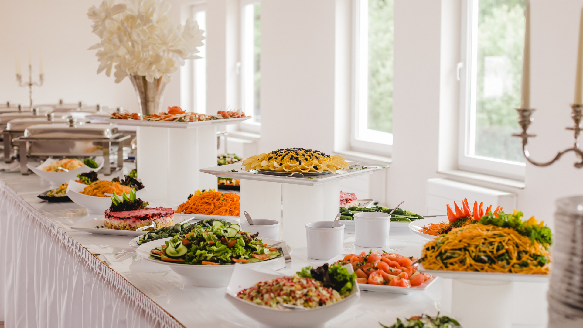 Abundant Caribbean and American catering buffet with jerk chicken, plantains, fresh salads and tropical fruit